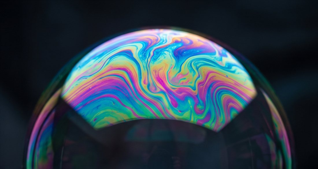 A giant soap bubble with swirling rainbow colours